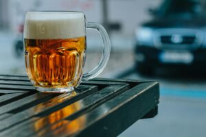 A frosty glass of pilsner beer on a wooden table at a beer garden in munich